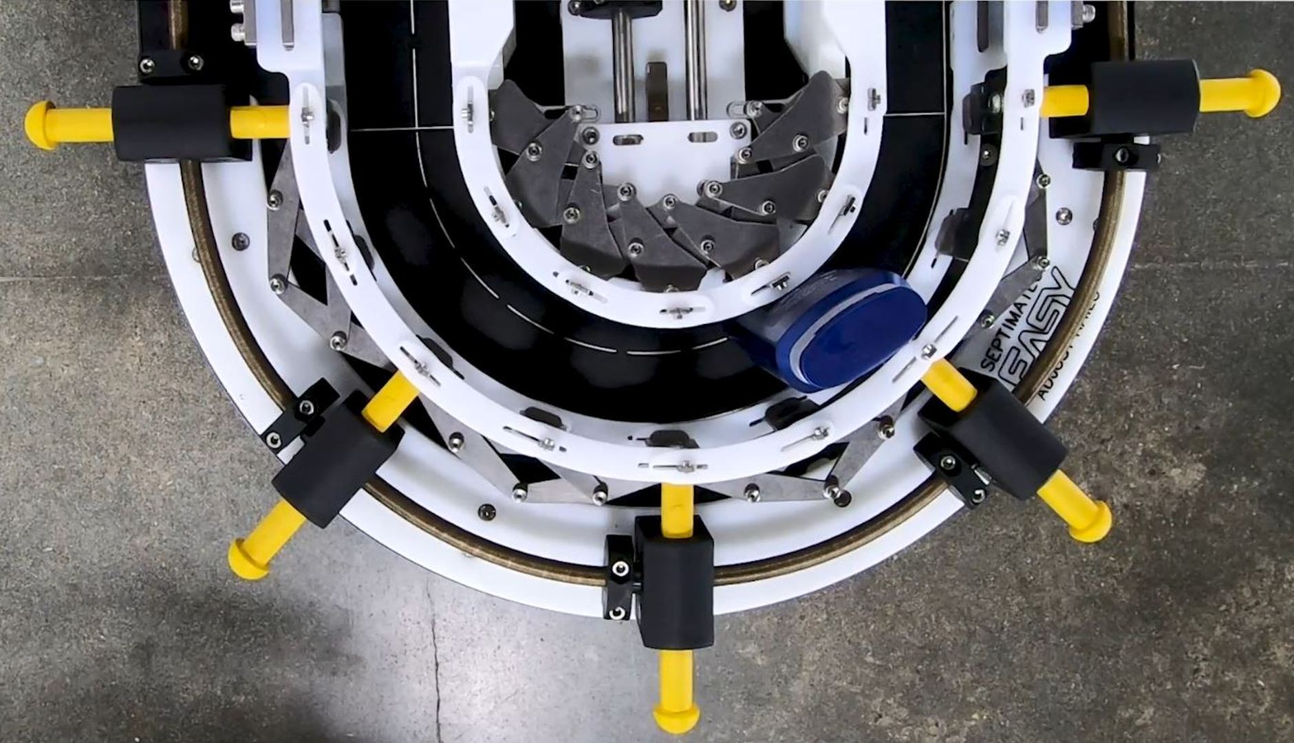 A top down view of a 180 degree corner that is outfitted with Septimatech's adjustable guiderail system. A single empty bottle runs around this conveyor's corner.